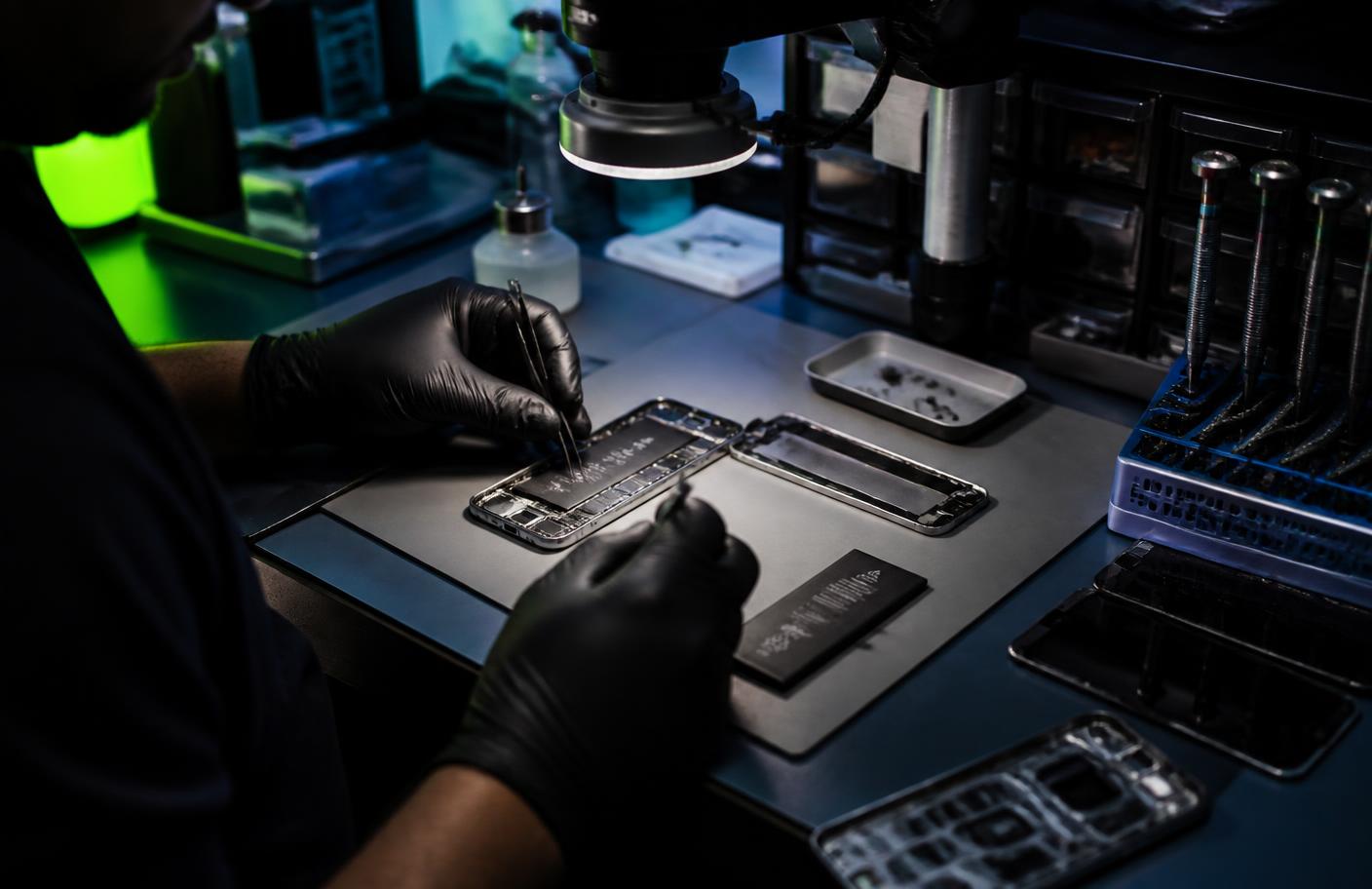 Bancada de assistência técnica com placa de celular sob microscópio